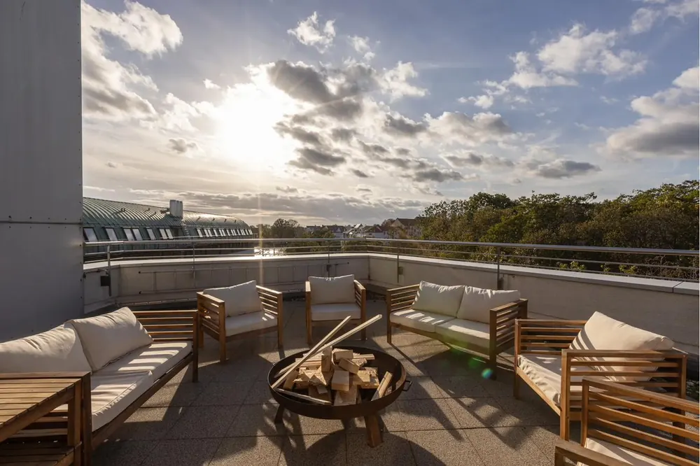 Gemeinschafts-Dachterrasse mit Loungemöbeln und Feuerschale