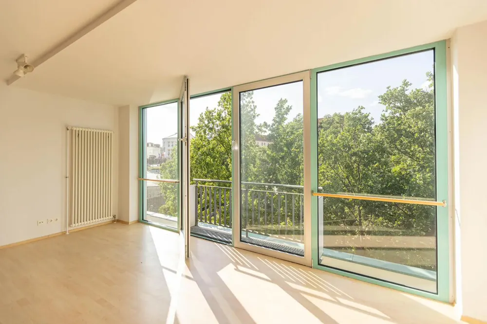 Lichtdurchflutetes Zimmer mit Balkon und Blick ins Grüne