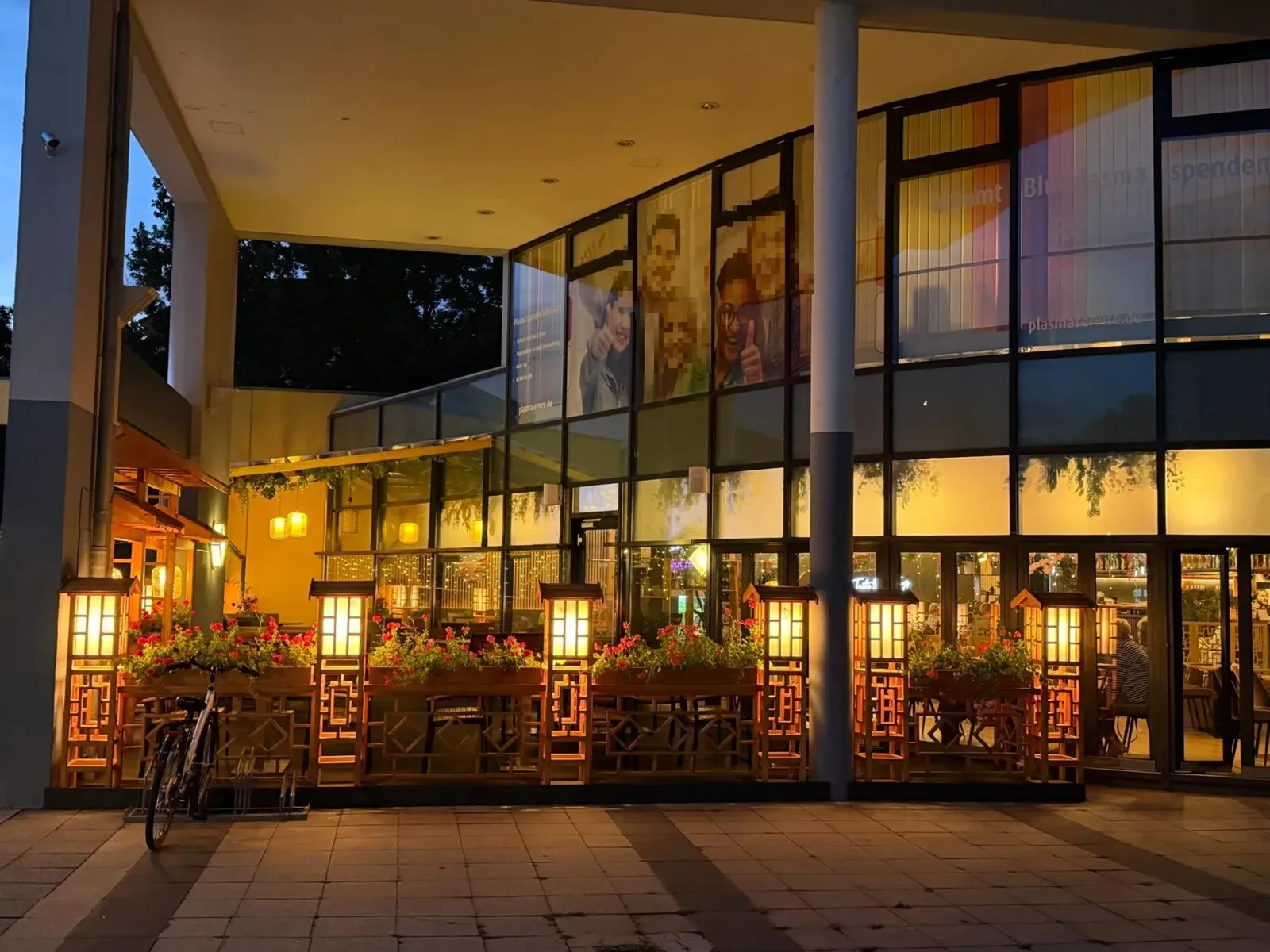Beleuchtete Ladenzeile unter dem Glasdach der Passage am Abend